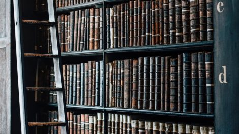 Estantería de una biblioteca antigua con volúmenes encuadernados.
