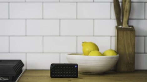 Altavoz Bluetooth negro sobre una superficie de madera.