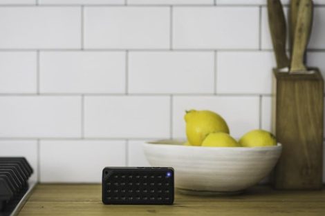 Altavoz Bluetooth negro sobre una superficie de madera.