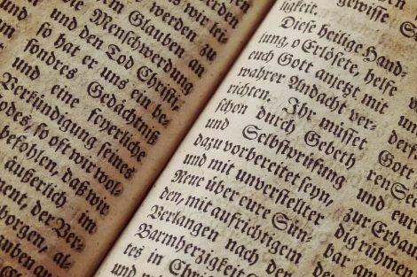Páginas de un libro antiguo abierto con texto a dos columnas.