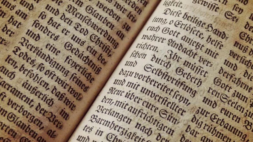 Páginas de un libro antiguo abierto con texto a dos columnas.