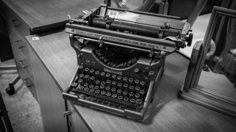 Máquina de escribir antigua sobre un escritorio de madera.