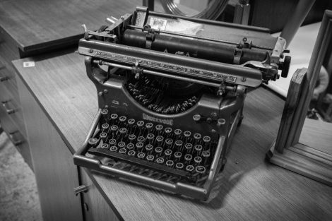 Máquina de escribir antigua sobre un escritorio de madera.