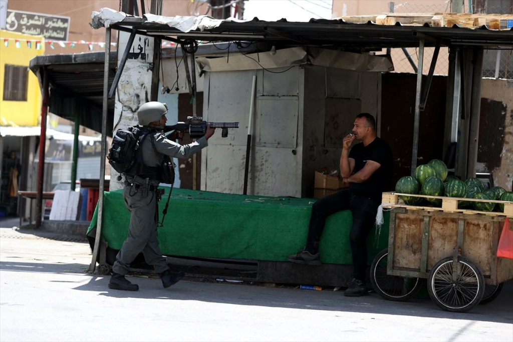 Foto de soldado israelí amenazando en Bethleem, territorio palestino ocupado, a un vendedor de frutas en el 2025, extraída de esta nota de prensa difundida en las redes sociales de AlJazeera
