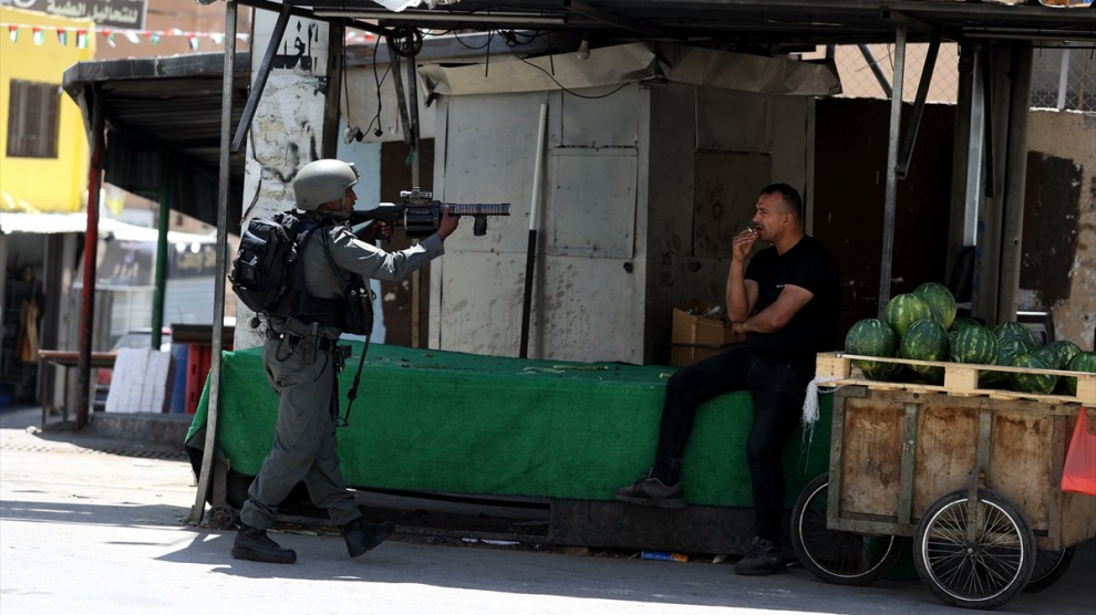 Foto de soldado israelí amenazando en Bethleem, territorio palestino ocupado, a un vendedor de frutas en el 2025, extraída de esta nota de prensa difundida en las redes sociales de AlJazeera